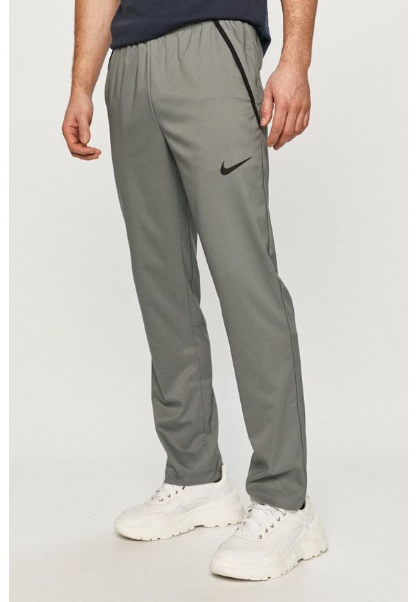Nike - Spodnie. Okazja: na co dzień. Kolor: szary. Materiał: tkanina, włókno, skóra. Styl: casual