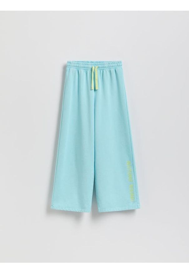 Reserved - Spodnie dresowe z nadrukiem - jasnoturkusowy. Kolor: turkusowy. Materiał: dresówka. Wzór: nadruk
