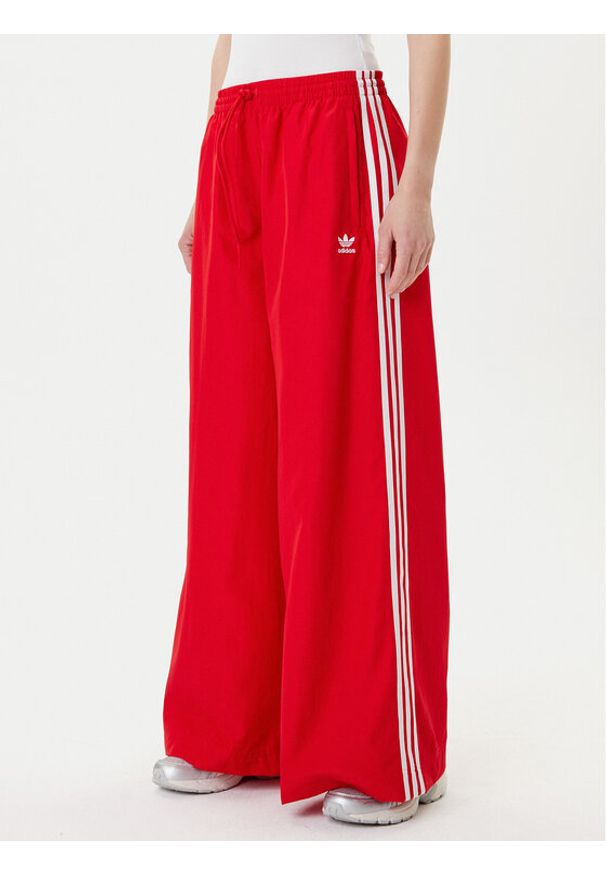 Adidas - adidas Spodnie dresowe adicolor Firebird JD3388 Czerwony Loose Fit. Kolor: czerwony. Materiał: syntetyk