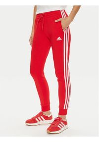 Adidas - adidas Spodnie dresowe Essentials 3-Stripes IY1719 Czerwony Slim Fit. Kolor: czerwony. Materiał: bawełna