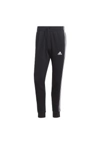 Adidas - Spodnie Essentials Fleece 3-Stripes Tapered Cuff. Kolor: biały, czarny, wielokolorowy. Materiał: polar, materiał