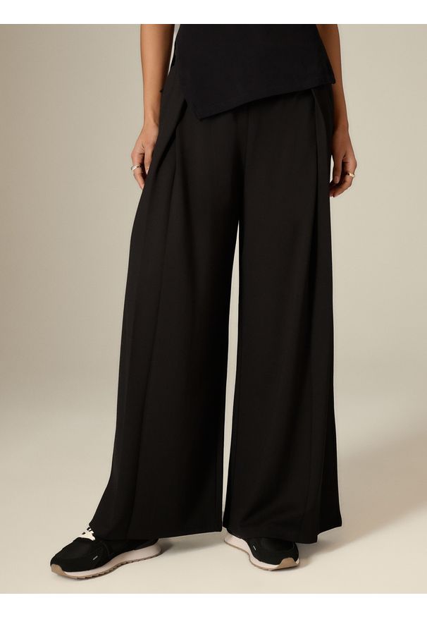 4f - 4F Spodnie dresowe z szerokimi nogawkami damskie - czarne S. Stan: podwyższony. Kolor: czarny. Materiał: dresówka