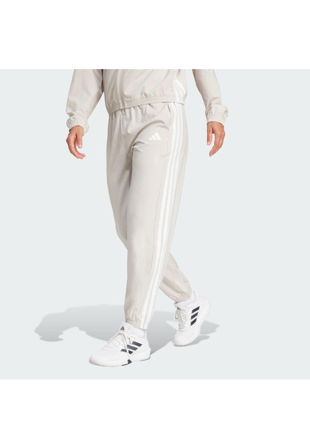 Adidas - Spodnie Train Essentials 3-Stripes Woven. Kolor: beżowy, wielokolorowy, biały. Materiał: materiał. Technologia: ClimaCool (Adidas). Sport: fitness
