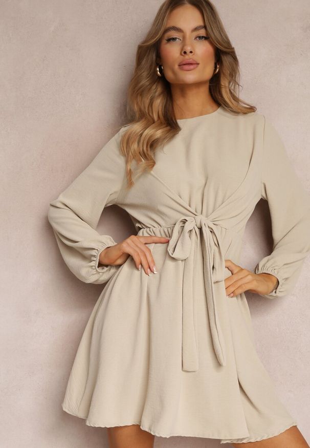 Renee - Jasnobeżowa Sukienka Rozkloszowana z Gumką w Pasie Thelo. Kolor: beżowy. Materiał: tkanina. Długość rękawa: długi rękaw. Wzór: gładki, jednolity. Styl: elegancki, klasyczny. Długość: mini