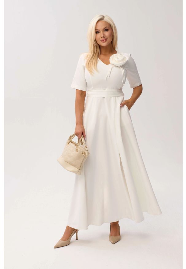 Moda Size Plus Iwanek - Sukienka MAXI Mirabella w odcieniu ecru/śmietankowej bieli z odpinanym kwiatem i kokardą OVERSIZE PLUS SIZE XXL WIOSNA LATO. Okazja: na urodziny, na wesele, na komunię, na ślub cywilny, na imprezę. Typ kołnierza: kokarda. Kolekcja: plus size. Wzór: kwiaty. Typ sukienki: oversize, dla puszystych. Materiał: tkanina, materiał, poliester, elastan. Sezon: lato, wiosna. Styl: elegancki, klasyczny. Długość: maxi