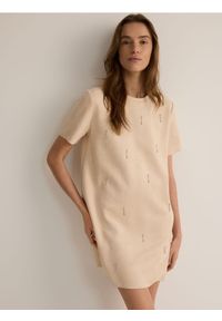 Reserved - Sukienka mini z aplikacjami - beżowy. Kolor: beżowy. Materiał: dzianina. Wzór: aplikacja. Typ sukienki: proste. Długość: mini #1