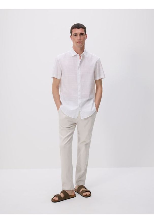 Reserved - Spodnie chino slim - beżowy. Kolor: beżowy. Materiał: bawełna