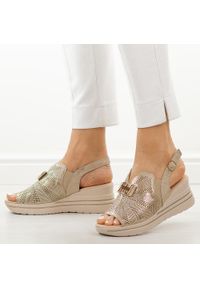 Złote skórzane sandały damskie na koturnie M.Daszyński 25144-4. Okazja: na co dzień. Kolor: złoty. Materiał: skóra. Wzór: aplikacja. Sezon: wiosna, lato. Obcas: na koturnie. Styl: casual, elegancki, klasyczny #1