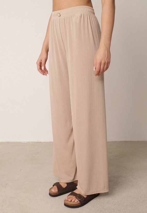 Born2be - Beżowe Spodnie z Wysokim Stanem i Szerokimi Nogawkami Zdobione Guzikiem Kelesh. Okazja: do pracy, na co dzień. Stan: podwyższony. Kolekcja: plus size. Kolor: beżowy. Materiał: tkanina, prążkowany. Długość: długie. Wzór: aplikacja. Styl: elegancki, casual