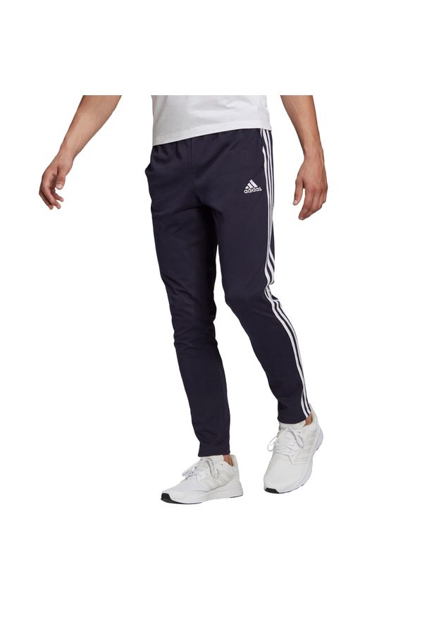 Adidas - Spodnie Essentials Single Jersey Tapered Open Hem 3-Stripes Rozmiar L Niebieski…. Kolor: niebieski. Materiał: jersey. Wzór: paski