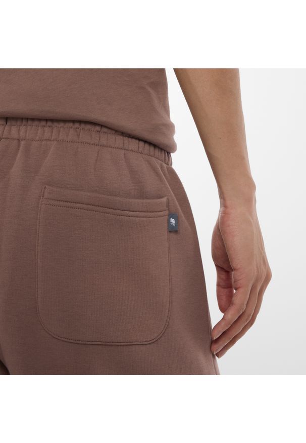 Spodnie męskie New Balance MP53508EAS – brązowe. Kolor: brązowy. Materiał: materiał, bawełna, dresówka, poliester. Wzór: napisy, aplikacja