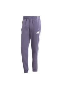 Adidas - Spodnie dresowe Manchester United UBP 2025/26. Kolor: fioletowy. Materiał: dresówka. Sport: piłka nożna #1