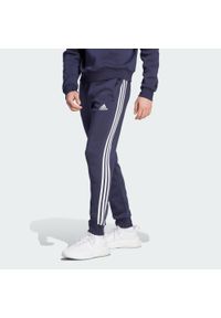 Adidas - Spodnie Essentials Fleece 3-Stripes Tapered Cuff. Kolor: czarny, niebieski. Materiał: polar, materiał