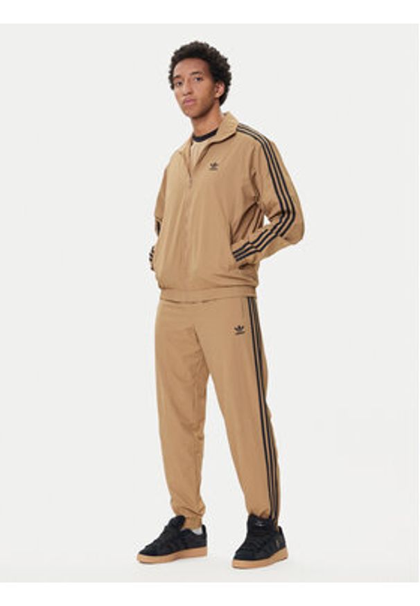 Adidas - adidas Spodnie dresowe adicolor Woven Firebird JY1339 Beżowy Regular Fit. Kolor: beżowy. Materiał: syntetyk