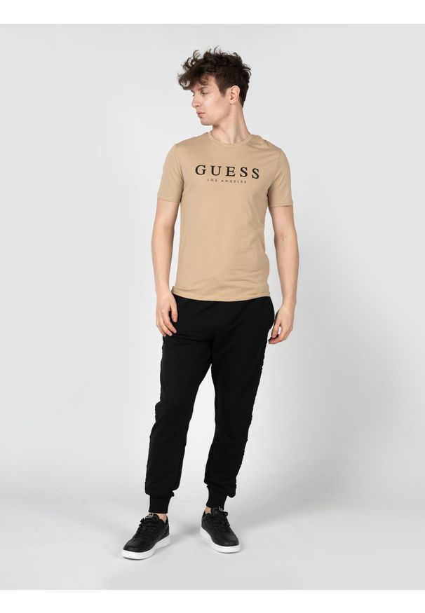 Guess T-Shirt "Leo" | X2BI14KBR42 | Mężczyzna | Beżowy. Okazja: na co dzień. Kolor: beżowy. Materiał: bawełna, poliester. Wzór: nadruk. Styl: casual, elegancki