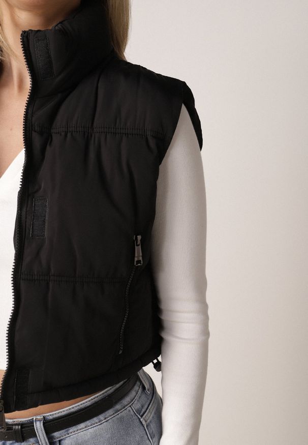 Born2be - Czarna Krótka Kamizelka Pikowana Typu Puffer Niraemius. Okazja: na co dzień. Typ kołnierza: kaptur. Kolor: czarny. Materiał: jeans, poliester. Długość: krótkie. Styl: sportowy, casual