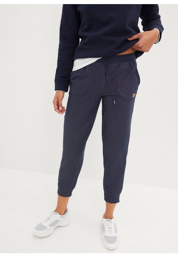 bonprix - Spodnie dresowe 7/8 w optyce dżinsowych. Kolor: niebieski