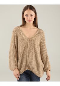 Unisono - BEŻOWY SWETER OVERSIZE. Typ kołnierza: dekolt w serek. Kolor: beżowy. Materiał: dzianina, prążkowany. Długość rękawa: długi rękaw. Długość: długie. Wzór: ze splotem