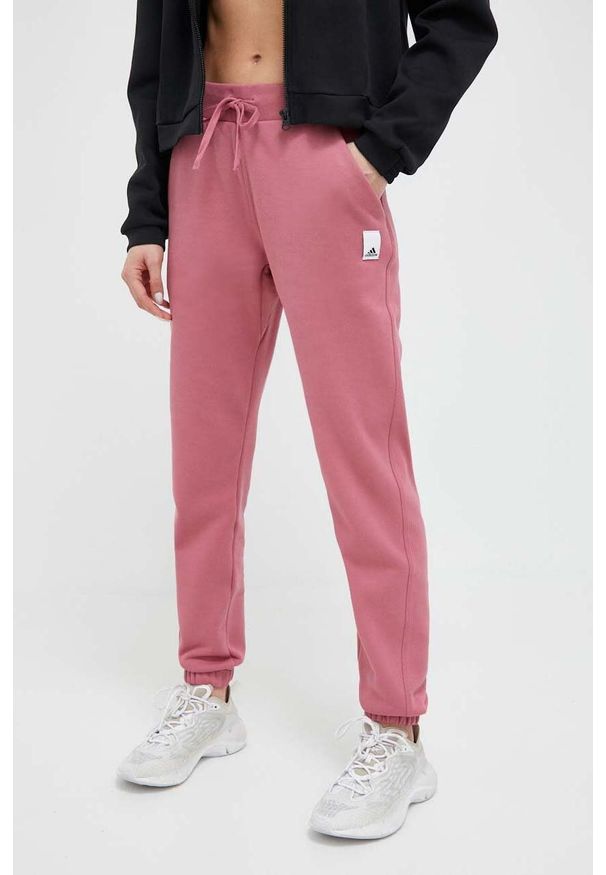 Adidas - adidas spodnie dresowe kolor pomarańczowy gładkie. Kolor: pomarańczowy. Materiał: dresówka. Wzór: gładki