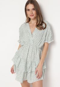 Born2be - Biało-Zielona Sukienka Mini z Falbankami i Kopertowym Dekoltem z Gumką w Talii Isarola. Typ kołnierza: kołnierz z falbankami. Kolor: biały. Wzór: kwiaty. Sezon: lato. Typ sukienki: kopertowe. Długość: mini #1