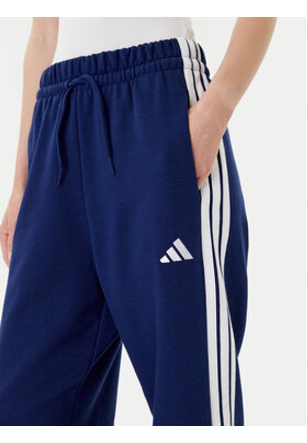 Adidas - adidas Spodnie dresowe Essentials 3-Stripes Fleece JX7696 Niebieski Loose Fit. Kolor: niebieski. Materiał: syntetyk