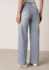 Born2be - Niebieskie Szerokie Jeansy Wysoki Stan z Bawełną Ozdobione Nitami Basithoe. Okazja: na co dzień. Stan: podwyższony. Kolor: niebieski. Wzór: aplikacja. Styl: casual, elegancki, klasyczny #7