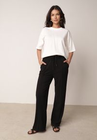 Born2be - Czarne Szerokie Spodnie z Prążkowanej Tkaniny z Wysokim Stanem Sarora. Okazja: na co dzień. Stan: podwyższony. Kolor: czarny. Materiał: tkanina, prążkowany. Wzór: prążki. Styl: casual #1