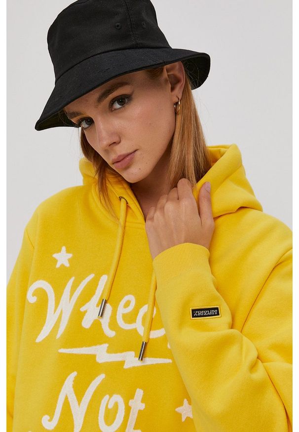 Superdry - Bluza. Typ kołnierza: kaptur. Kolor: żółty. Długość rękawa: długi rękaw. Długość: długie. Wzór: nadruk