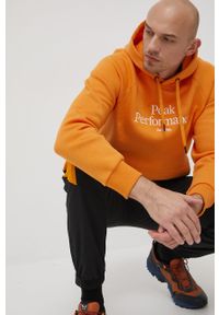 Peak Performance bluza męska kolor pomarańczowy z kapturem z aplikacją. Typ kołnierza: kaptur. Kolor: pomarańczowy. Materiał: dzianina. Długość rękawa: raglanowy rękaw. Wzór: aplikacja