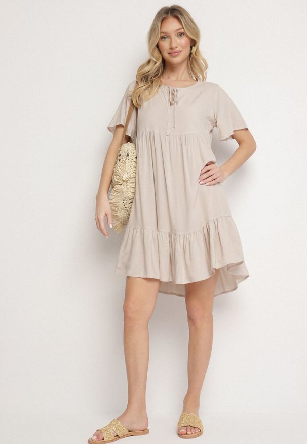 Born2be - Jasnobeżowa Sukienka z Bawełny o Rozkloszowanym Kroju z Wiązaniem przy Dekolcie Mepilea. Okazja: na co dzień. Kolor: beżowy. Materiał: bawełna. Długość rękawa: krótki rękaw. Sezon: wiosna, lato. Typ sukienki: rozkloszowane. Styl: elegancki, klasyczny, casual