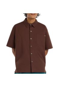 Koszula męska New Balance Numeric MT61J0V9ABJ - brązowa. Typ kołnierza: kołnierzyk klasyczny. Kolor: brązowy. Materiał: materiał, bawełna, nylon, dresówka, elastan. Wzór: aplikacja #1