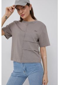 Reebok t-shirt HB1064 damski kolor beżowy. Kolor: beżowy. Materiał: poliester, materiał, dzianina. Długość rękawa: krótki rękaw. Długość: krótkie. Wzór: gładki #1