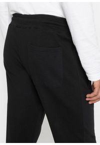 bonprix - Spodnie ze sportowym nadrukiem uszyte z czystej bawełny. Kolor: czarny. Materiał: bawełna. Wzór: nadruk. Styl: sportowy #2