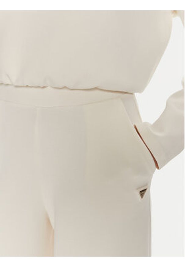 Guess Spodnie dresowe Olympe V4YB07 KCAY2 Beżowy Relaxed Fit. Kolor: beżowy. Materiał: syntetyk