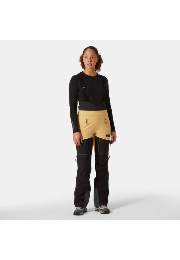 Damskie spodnie narciarskie na szelkach Helly Hansen Odin BC Softshell. Kolor: wielokolorowy, żółty, beżowy. Materiał: softshell. Sezon: zima. Sport: narciarstwo