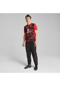 Puma - Męska koszulka przedmeczowa z krótkim rękawem AC Milan PUMA. Kolor: czerwony, wielokolorowy, czarny. Długość rękawa: krótki rękaw. Długość: krótkie