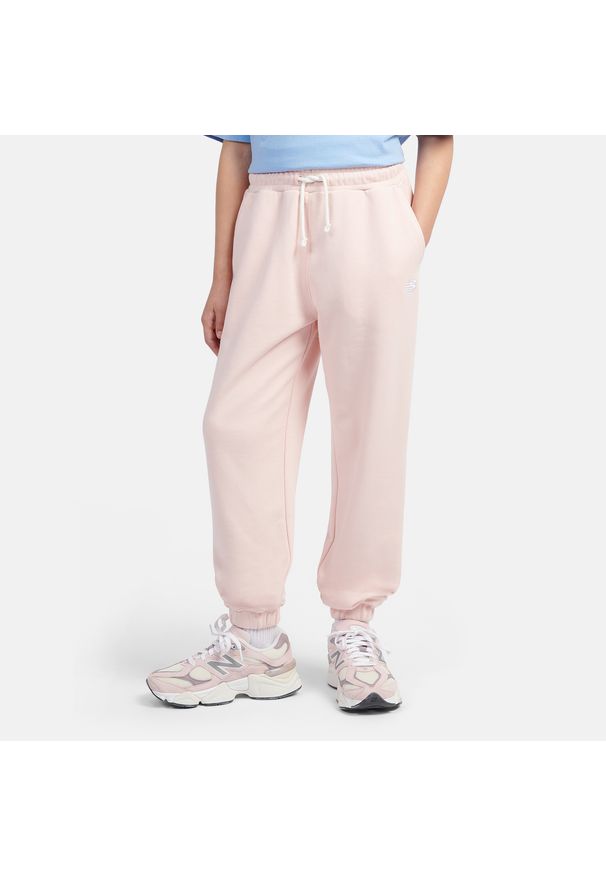 Spodnie dziecięce New Balance LAKG0058PIE – różowe. Kolor: różowy. Materiał: bawełna, poliester, dresówka