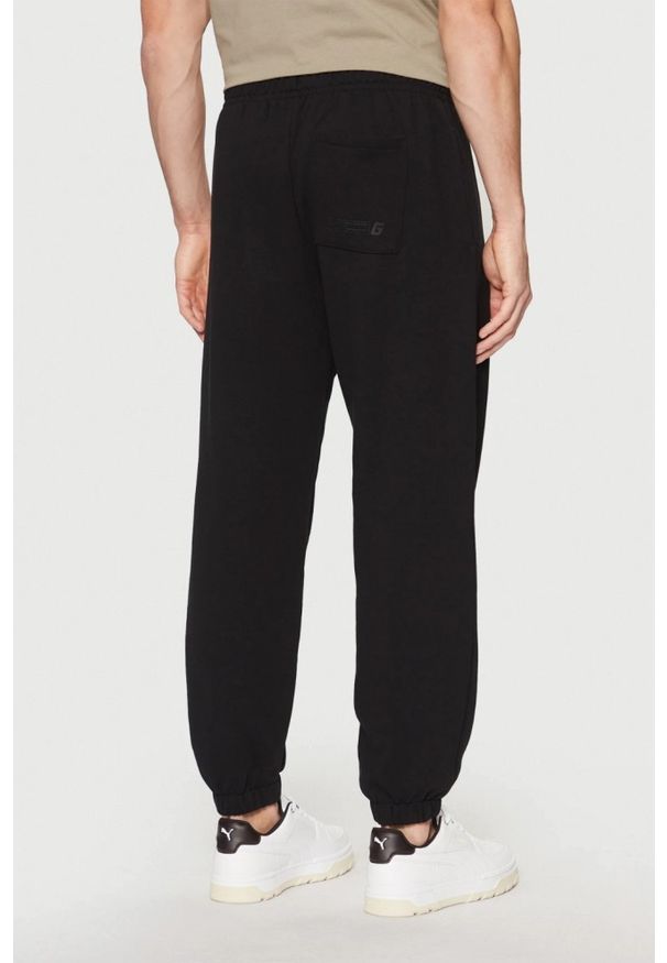 Guess - GUESS Czarne męskie spodnie dresowe Emis, Rozmiar XL. Kolor: czarny. Materiał: dresówka