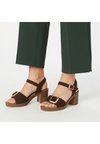 Sandały damskie Tamaris, cholewka ze skóry zamszowej na stabilnym słupku z szerokimi paskami i regulowanym zapięciem przy kostce ozdobione dużą klamr. Okazja: na co dzień. Zapięcie: pasek. Kolor: brązowy. Wzór: aplikacja. Materiał: zamsz, skóra. Sezon: lato. Obcas: na słupku. Styl: casual, elegancki, klasyczny. Wysokość obcasa: średni #1