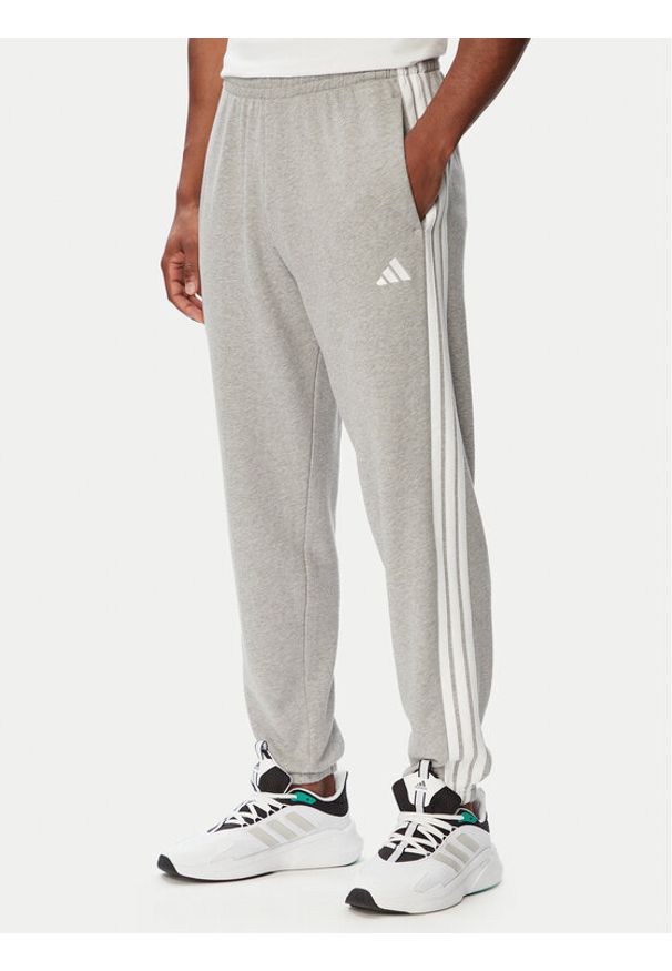 Adidas - adidas Spodnie dresowe Essentials 3-Stripes KY4195 Szary jasny Regular Fit. Kolor: szary. Materiał: bawełna