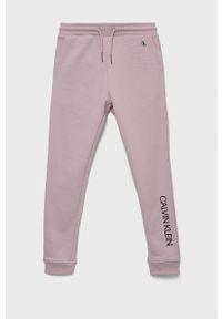 Calvin Klein Jeans spodnie dresowe bawełniane dziecięce kolor różowy z nadrukiem. Kolor: różowy. Materiał: bawełna, dresówka. Wzór: nadruk #1