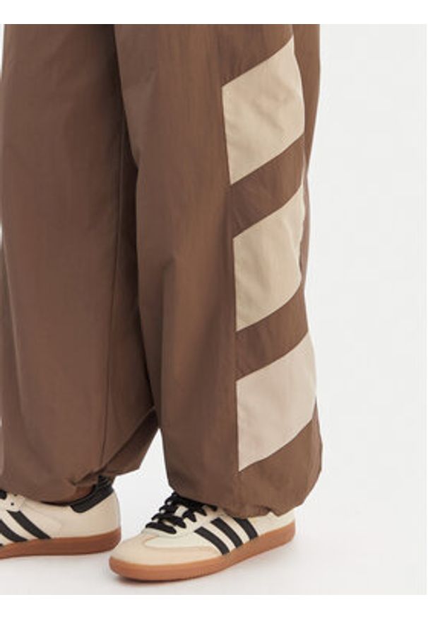 Adidas - adidas Spodnie dresowe Blocked Washed KD8790 Brązowy Loose Fit. Kolor: brązowy. Materiał: syntetyk