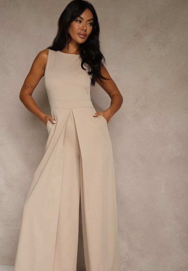 Renee - Beżowy Taliowany Kombinezon Ozdobiony Zakładkami Berinola. Okazja: na imprezę. Kolor: beżowy. Wzór: aplikacja. Styl: elegancki