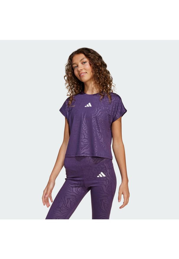 Adidas - Koszulka All Sports Animal Print Crop. Kolor: fioletowy, biały, wielokolorowy. Wzór: nadruk. Sport: joga i pilates