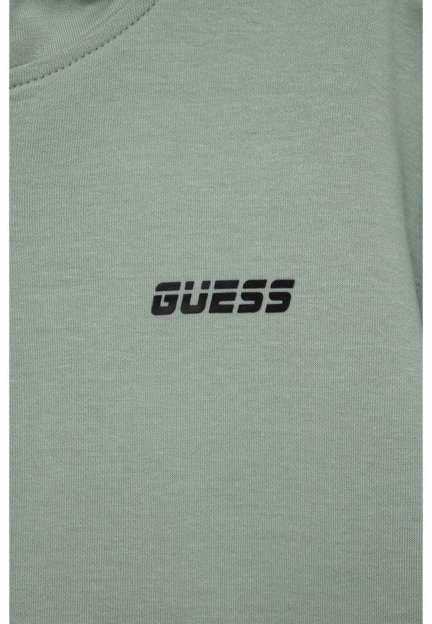 Guess Bluza dziecięca kolor zielony z kapturem gładka. Okazja: na co dzień. Typ kołnierza: kaptur. Kolor: zielony. Materiał: bawełna. Wzór: gładki. Styl: casual
