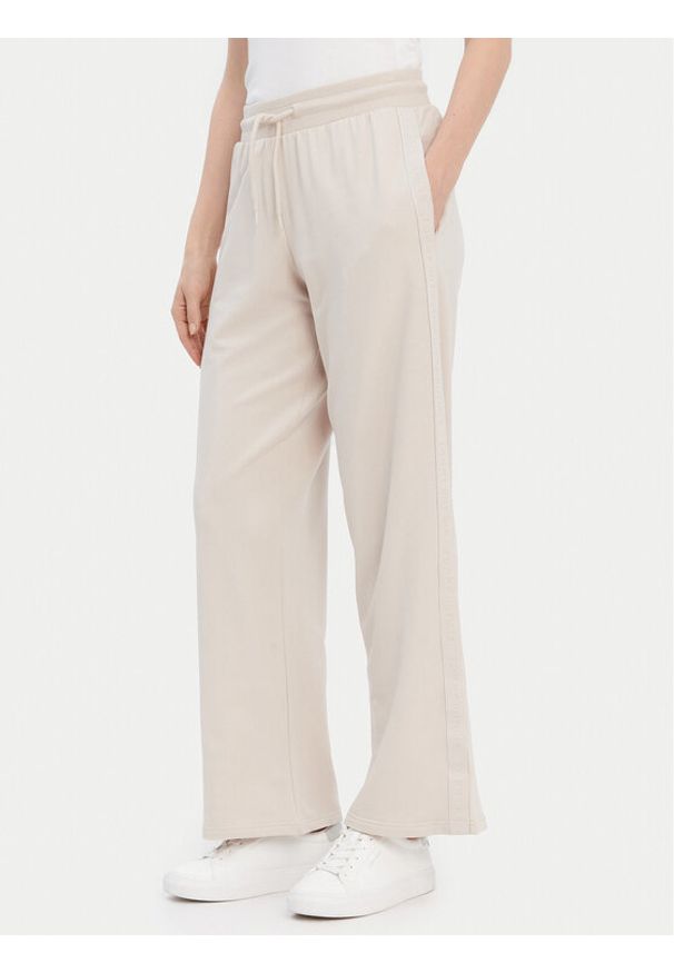 TOMMY HILFIGER - Tommy Hilfiger Spodnie dresowe UW0UW04771 Beżowy Relaxed Fit. Kolor: beżowy. Materiał: dresówka