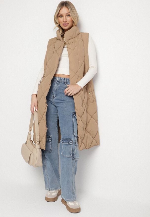 Born2be - Ciemnobeżowa Pikowana Kamizelka o Długim Kroju ze Stójką i Kieszeniami Avatheia. Okazja: na co dzień. Typ kołnierza: kołnierzyk stójkowy. Kolor: beżowy. Materiał: jeans. Długość: długie. Wzór: aplikacja. Styl: klasyczny, casual, elegancki