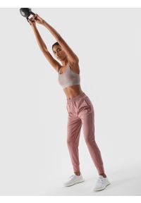 4f - Spodnie treningowe szybkoschnące damskie - pudrowy róż. Kolor: różowy. Materiał: syntetyk, elastan, materiał, włókno, dzianina. Wzór: ze splotem, jednolity. Sport: fitness #1