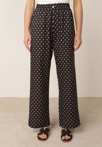 Born2be - Czarne Spodnie Casual w Groszki z Szerokimi Nogawkami i Wysokim Stanem Soleano. Okazja: na co dzień. Stan: podwyższony. Kolekcja: plus size. Kolor: czarny. Materiał: koronka. Długość: długie. Wzór: grochy. Styl: casual #1