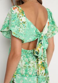 Born2be - Zielona Sukienka z Gumką w Pasie Ozdobiona Falbanką Guzikami i Wiązaniem na Plecach Dimiila. Okazja: na co dzień. Typ kołnierza: kołnierz z falbankami. Kolor: zielony. Długość rękawa: krótki rękaw. Wzór: aplikacja. Sezon: lato. Styl: casual #5